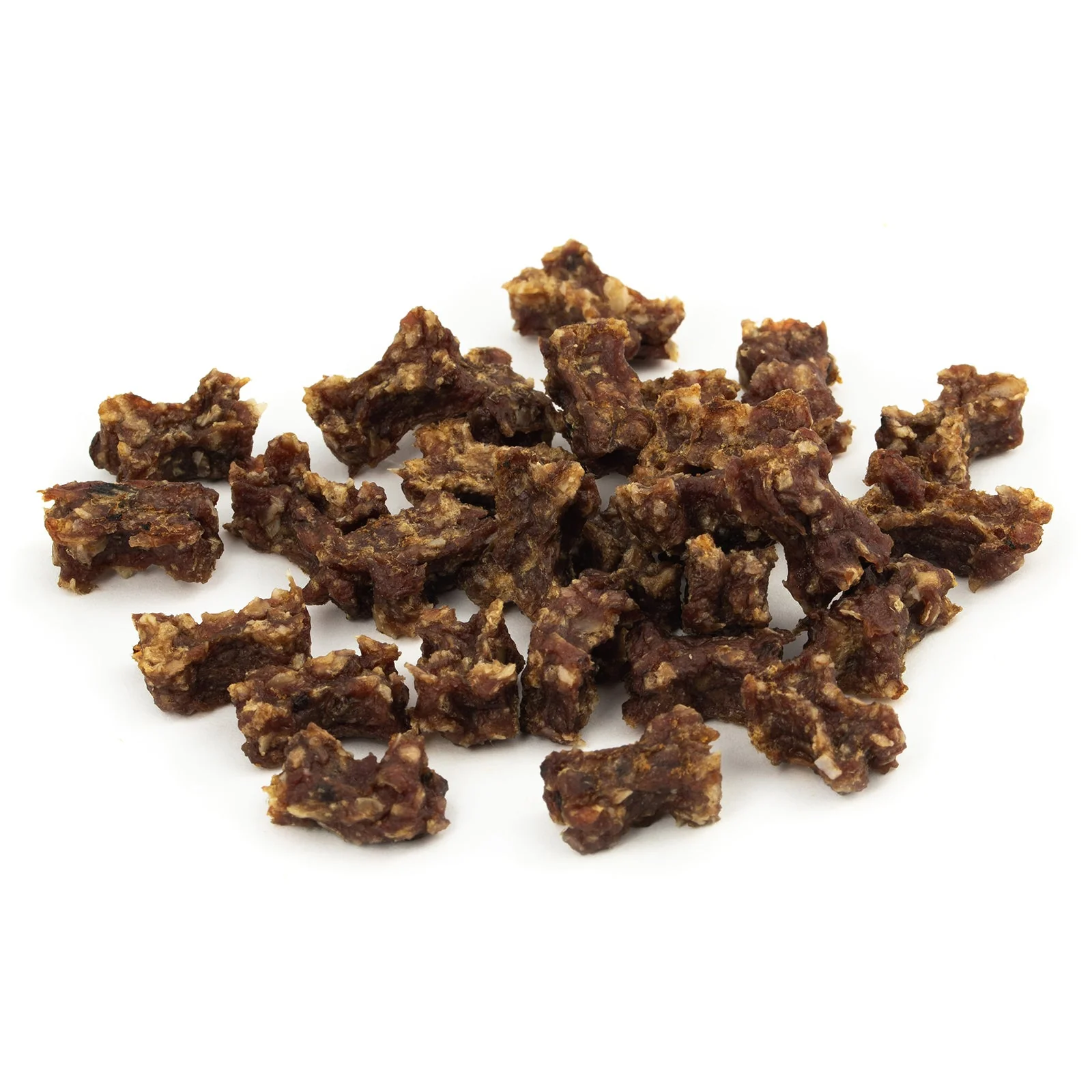 Beef jerky bites scattered on a white surface, showing irregular dark brown chunks with lighter dried fat areas.