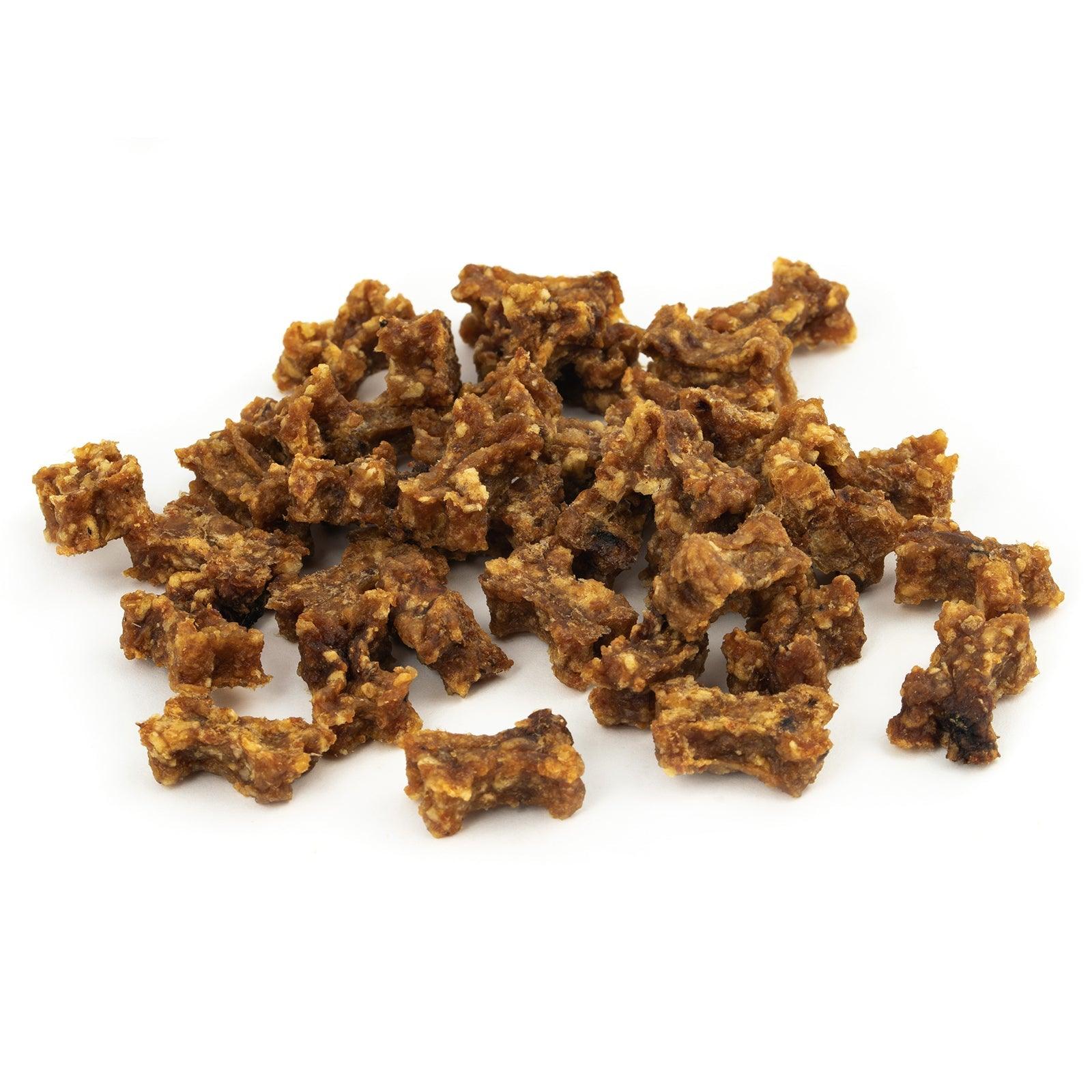 Pile of crispy fried pork cracklings scattered on a white surface, golden brown and chunky.
