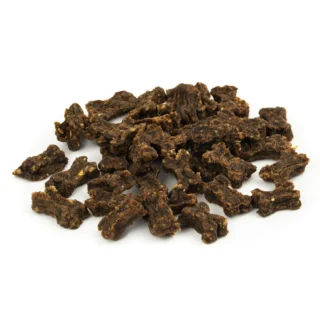 Irregular dark brown jerky pieces scattered on a white background, bite-sized chunks of dried meat highlights.",