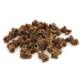 Assorted chunks of beef jerky scattered on a white background.