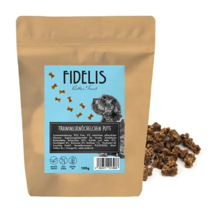 Brown resealable pouch of Fidelis dog treats with a blue label showing a dog and bone shapes; text reads 'Trainingsknöchelchen Pute' and '100g' beside scattered kibble pieces.